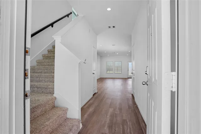 a view of a hallway with wooden floor and staircase