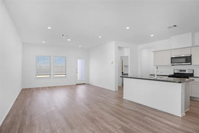 a kitchen with stainless steel appliances granite countertop a stove a sink and a refrigerator