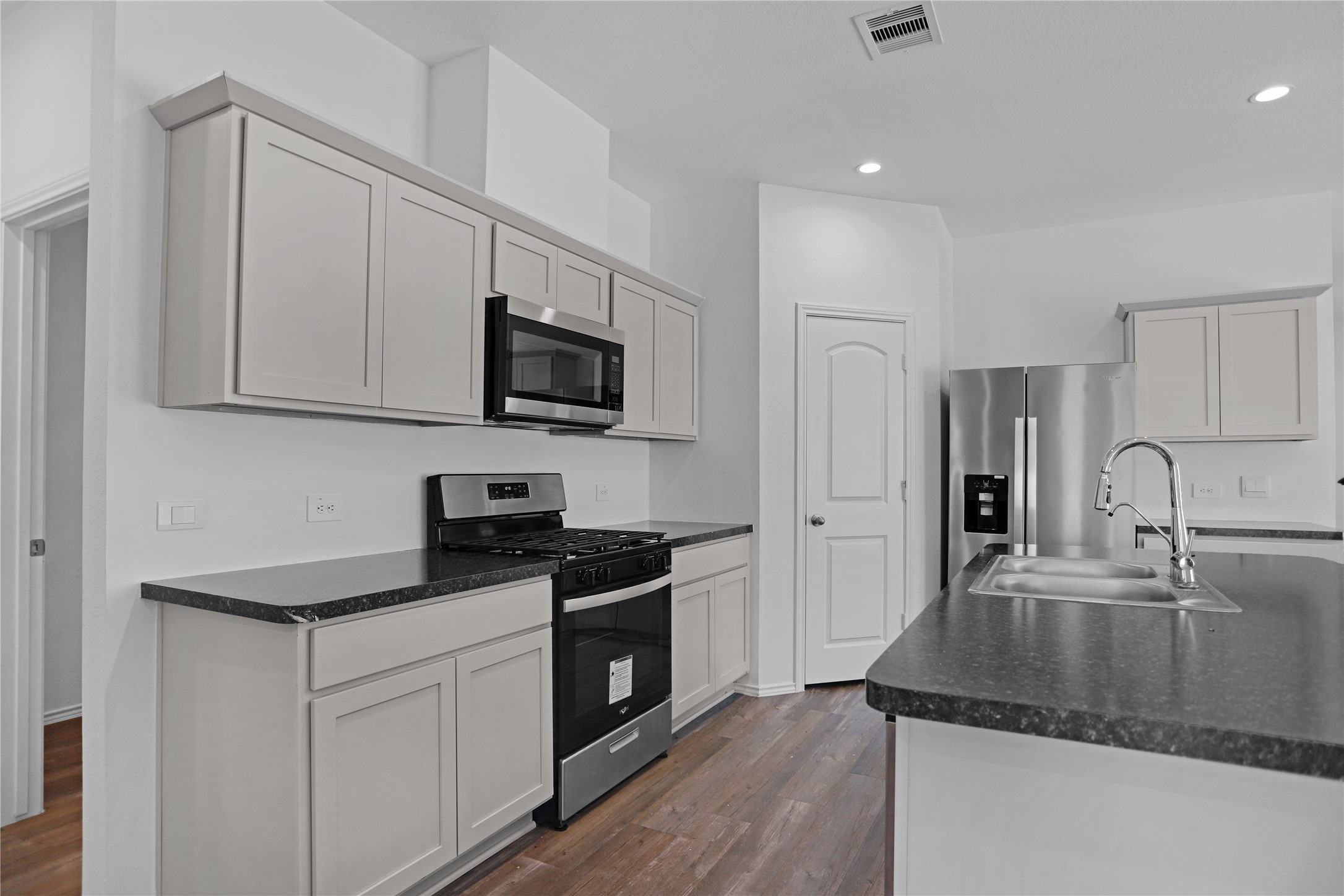 24311 Saddlestone Green Dr Spring Spring, TX 77373 - Photo 8 of 36 a kitchen with stainless steel appliances granite countertop a sink a stove a microwave and wooden cabinets