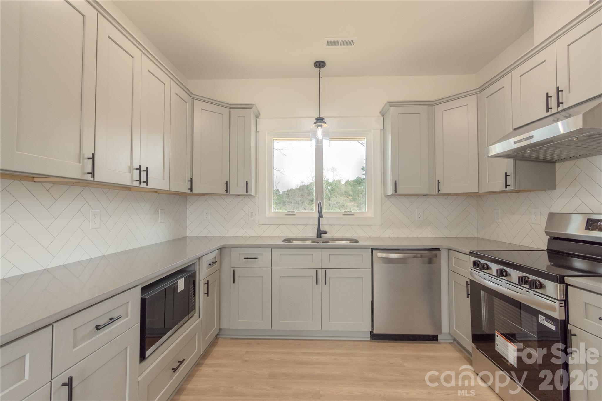 10303 Sycamore Road, Unit 90 Norwood, NC 28128 - Photo 13 of 42 a kitchen with a sink stove and cabinets