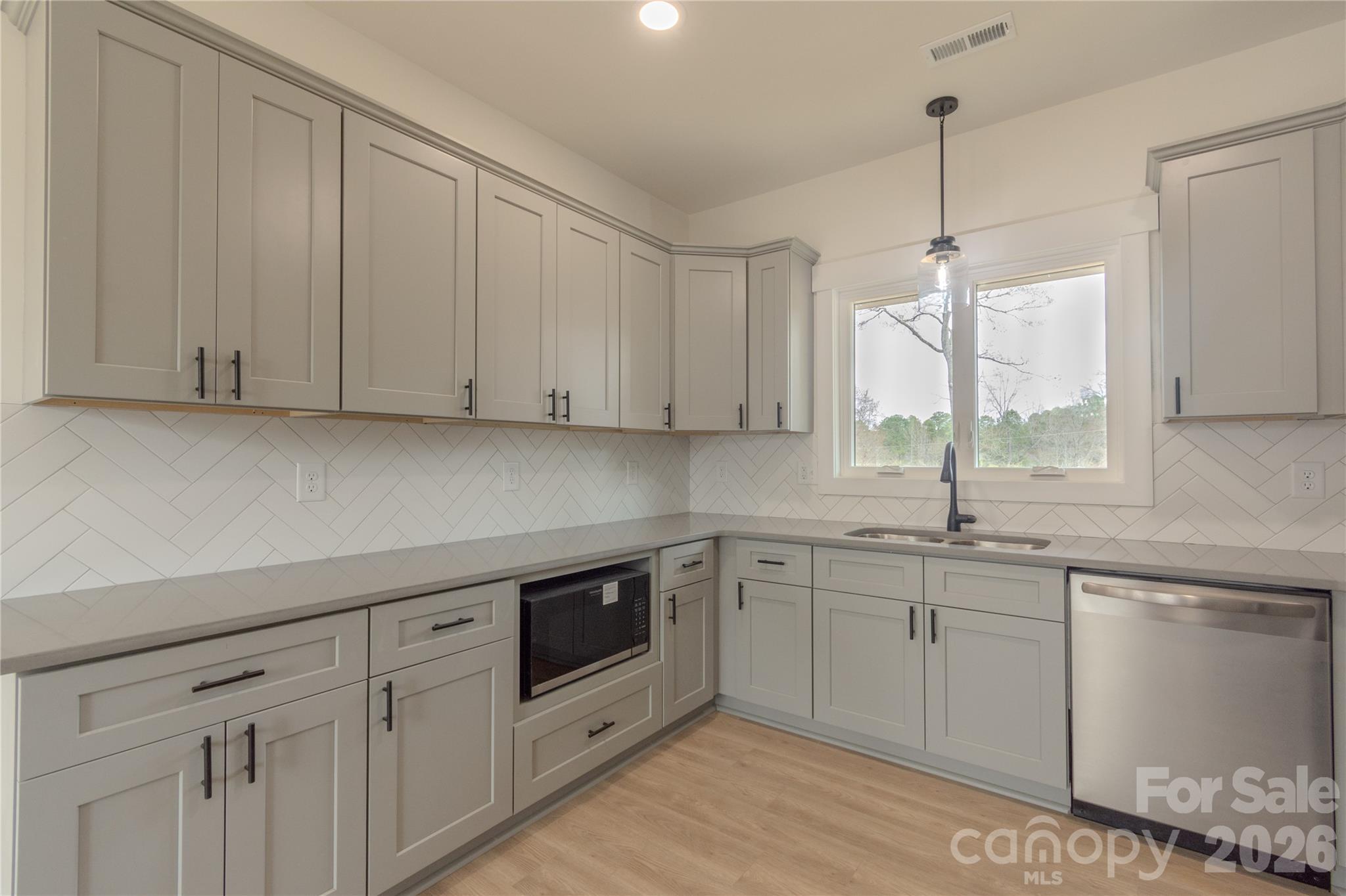 10303 Sycamore Road, Unit 90 Norwood, NC 28128 - Photo 15 of 42 a kitchen with white cabinets sink and window