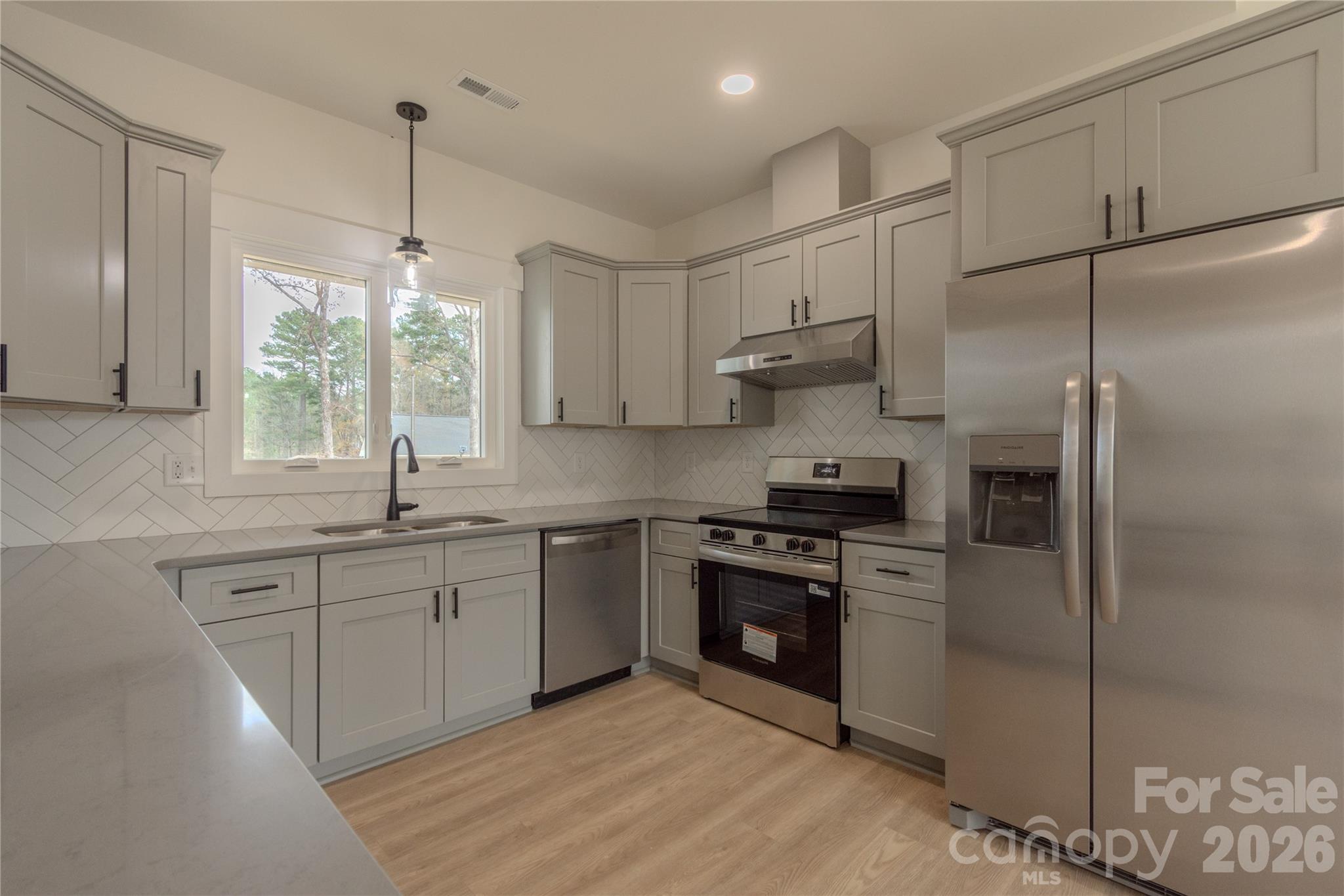 10303 Sycamore Road, Unit 90 Norwood, NC 28128 - Photo 16 of 42 a kitchen with stainless steel appliances granite countertop a sink stove and refrigerator
