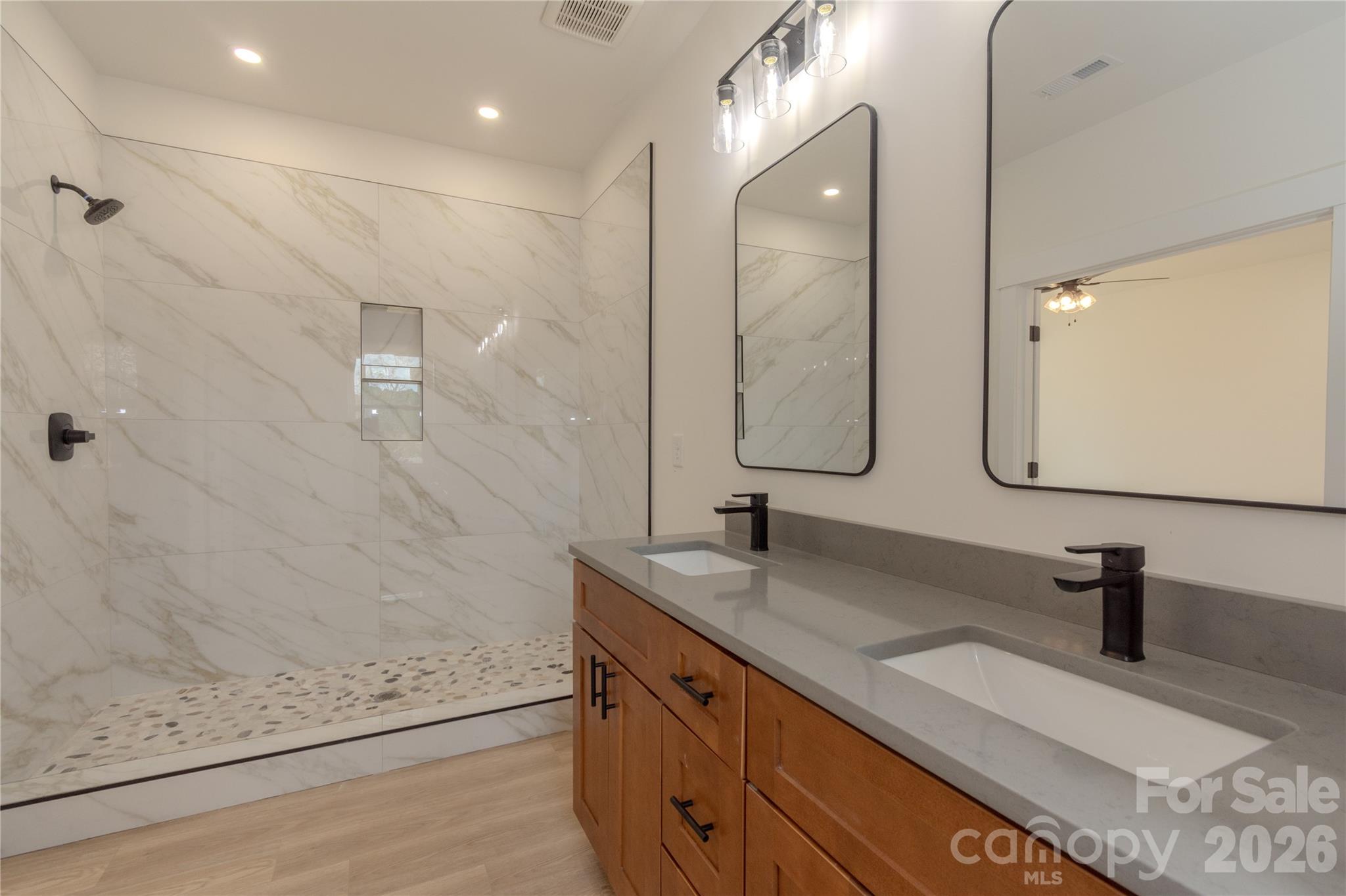 10303 Sycamore Road, Unit 90 Norwood, NC 28128 - Photo 26 of 42 a bathroom with a double vanity sink mirror and shower