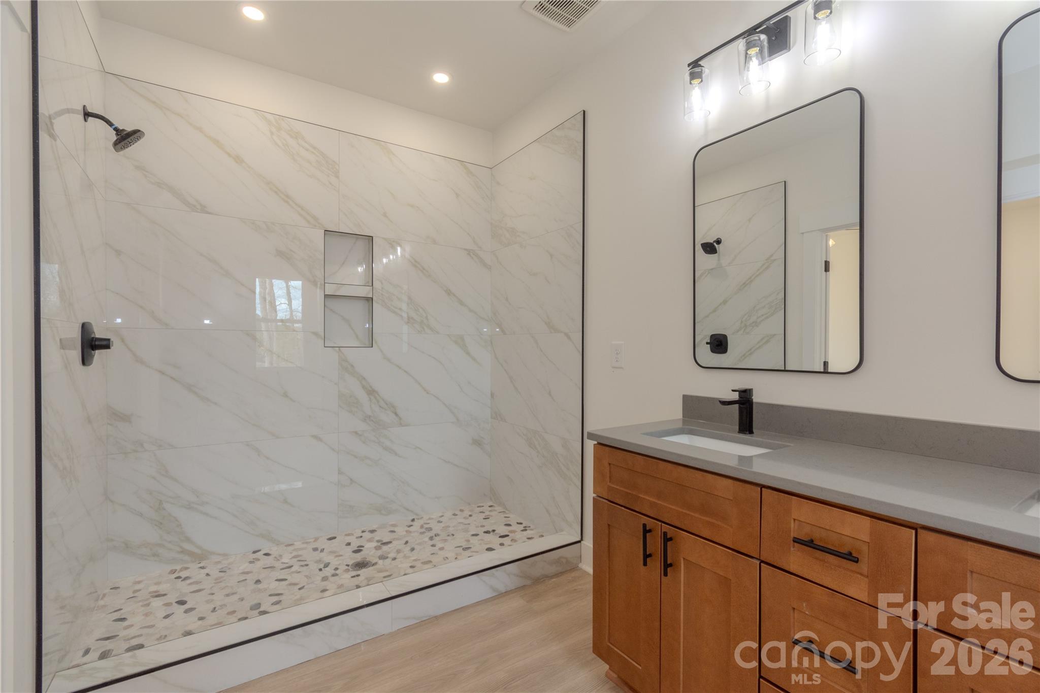 10303 Sycamore Road, Unit 90 Norwood, NC 28128 - Photo 27 of 42 a bathroom with a granite countertop sink a mirror and shower