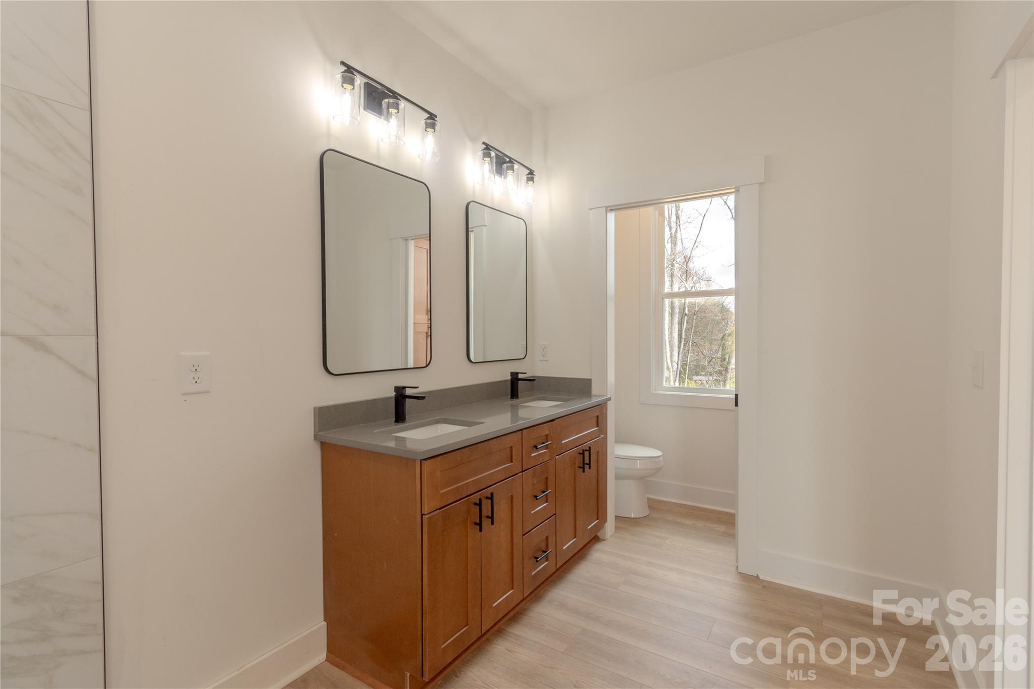 10303 Sycamore Road, Unit 90 Norwood, NC 28128 - Photo 29 of 42 a bathroom with a granite countertop sink and a mirror
