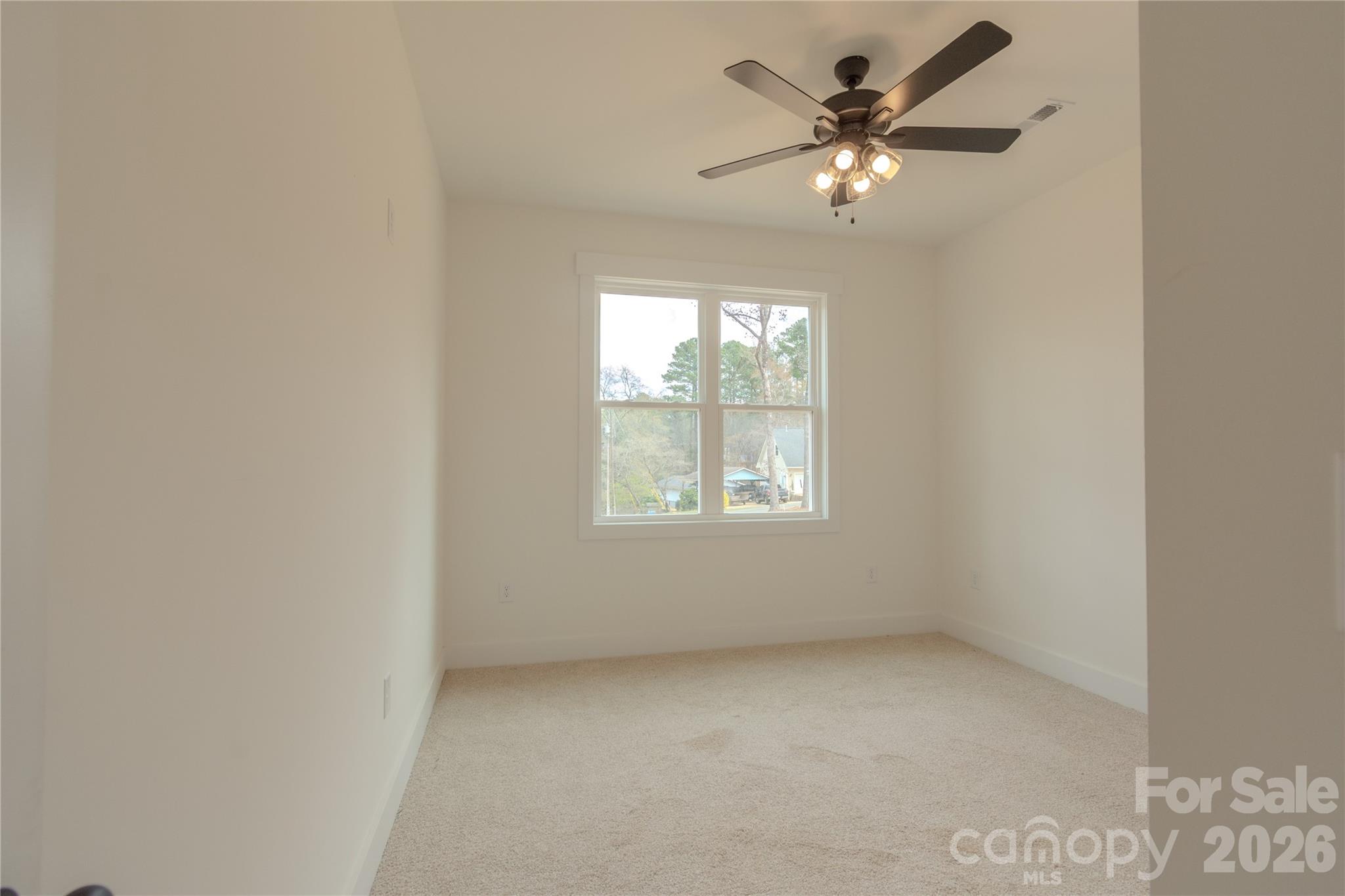 10303 Sycamore Road, Unit 90 Norwood, NC 28128 - Photo 41 of 42 an empty room with a window and a ceiling fan