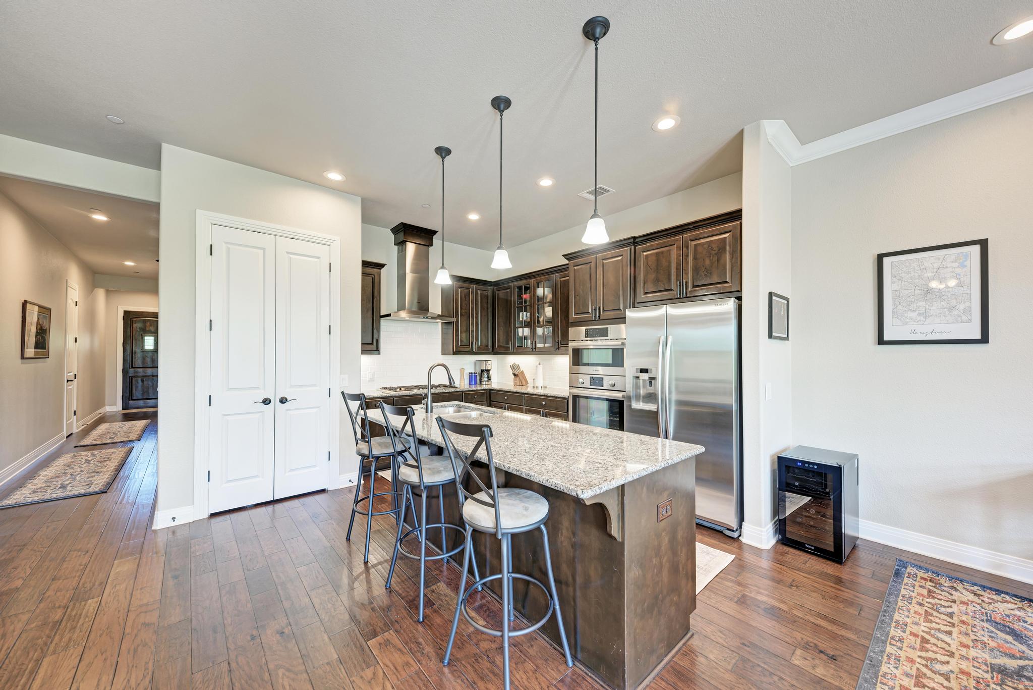 2601 North Quinlan Park Road, Unit 506 Austin, TX 78732 - Photo 14 of 39 Prepare culinary delights in this kitchen featuring abundant dark cabinetry and a central granite island with casual seating.