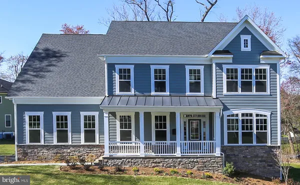 a front view of a house with yard and green space