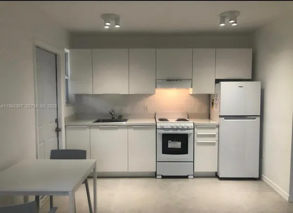 a kitchen with cabinets stainless steel appliances and sink