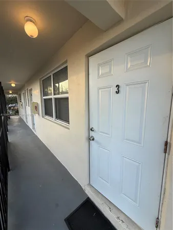 a view of a hallway with wooden floor and cabinet