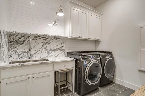 a utility room with sink dryer and washer