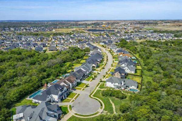 an aerial view of residential houses with outdoor space and trees