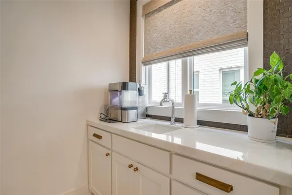 a bathroom with a granite countertop sink a potted plant and a window