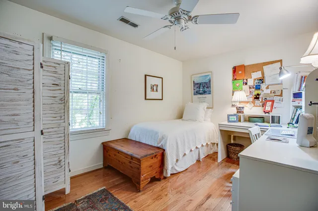 a bedroom with a bed wooden floor and window