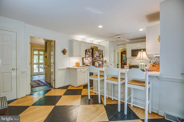 a room with lots of white furniture and a rug