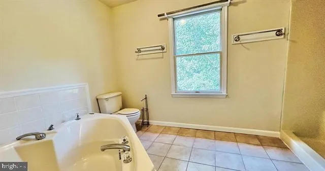 a bathroom with a tub and toilet