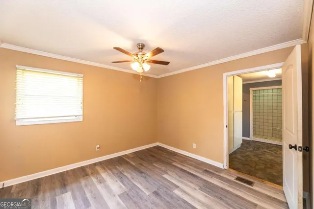 a view of a big room with wooden floor and a ceiling fan