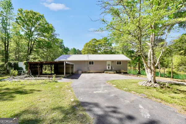 a view of a house with backyard and tree