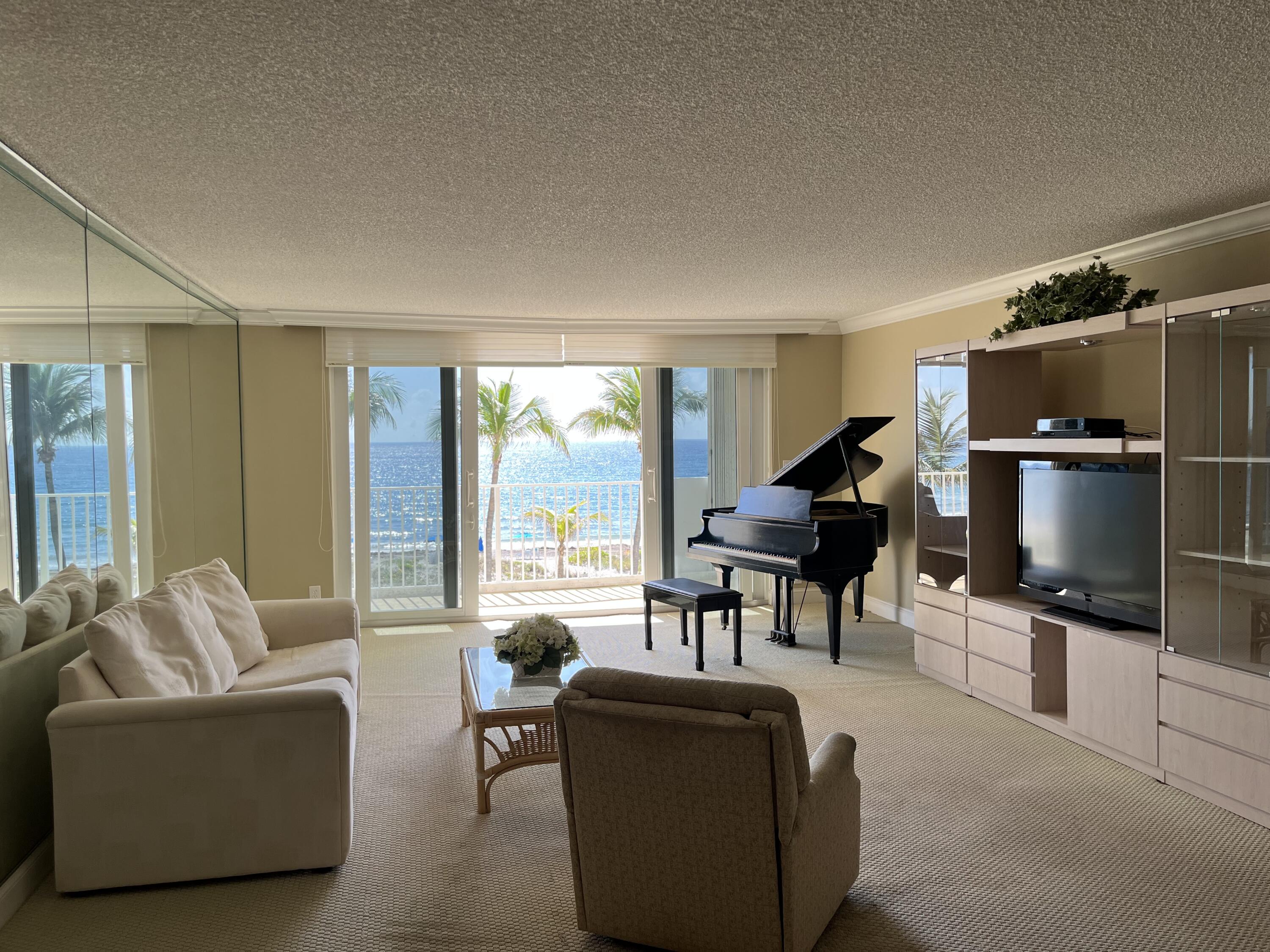 3000 South Ocean Boulevard, Unit 304 Boca Raton, FL 33432 - Photo 4 of 41 a living room with furniture a floor to ceiling window and a flat screen tv