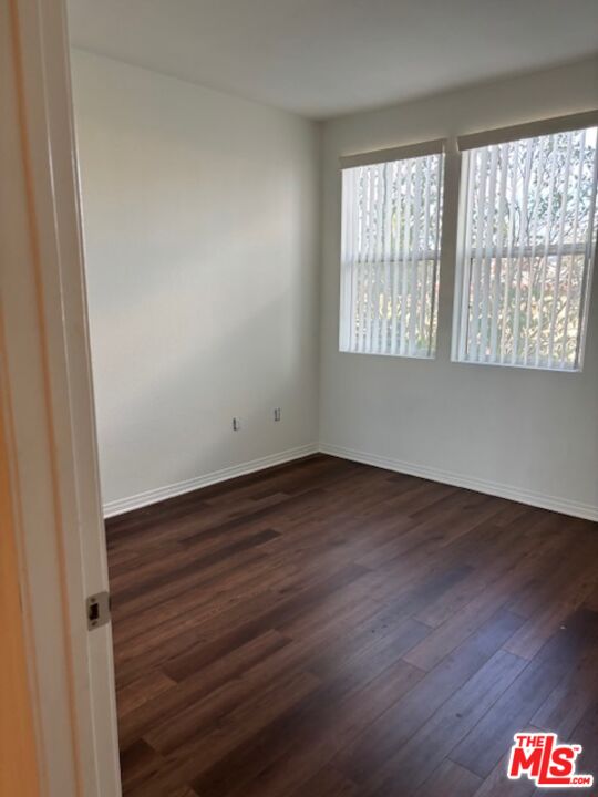 11925 Kling Street, Unit 311 Valley Village, CA 91607 - Photo 23 of 25 an empty room with wooden floor and windows