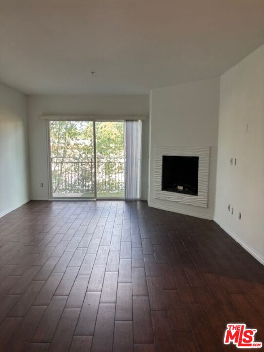 11925 Kling Street, Unit 311 Valley Village, CA 91607 - Photo 24 of 25 an empty room with wooden floor fire place and windows