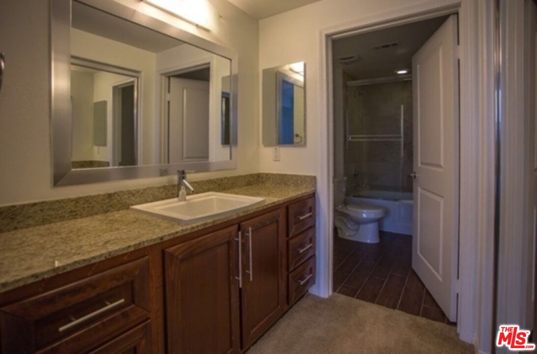 11925 Kling Street, Unit 311 Valley Village, CA 91607 - Photo 6 of 25 a bathroom with a sink and a mirror