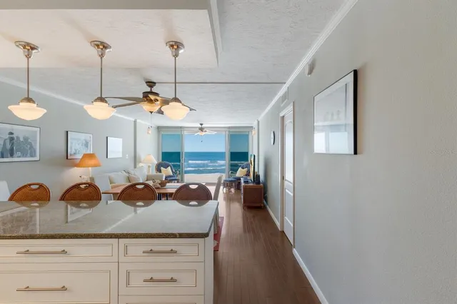 a kitchen with stainless steel appliances granite countertop a refrigerator a stove a sink dishwasher a oven with white cabinets and wooden floor