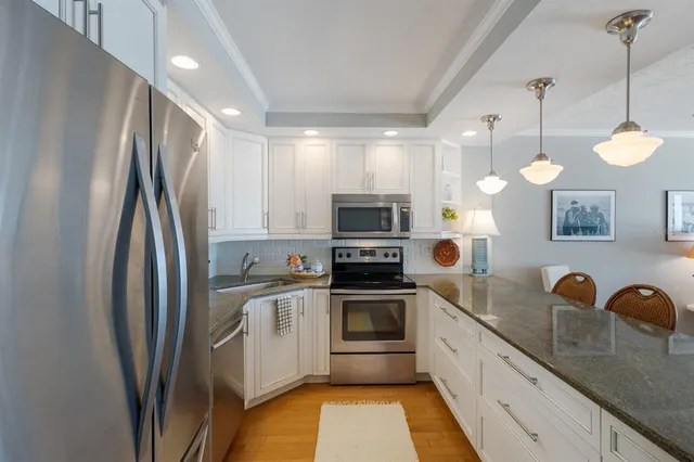 a living room with furniture kitchen view and a chandelier