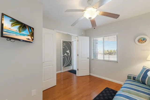 a living room with furniture and a large mirror with wooden floor