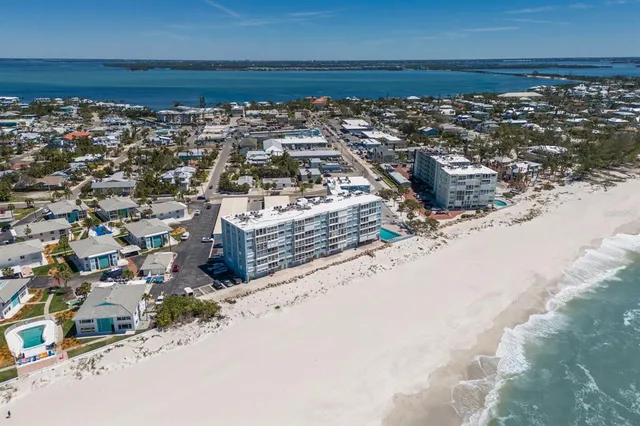 a view of a kitchen with granite countertop a sink a stove a dining table and chairs