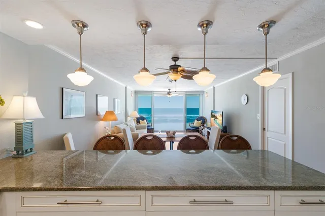 a kitchen with stainless steel appliances granite countertop a refrigerator a oven a sink with a countertop and chairs