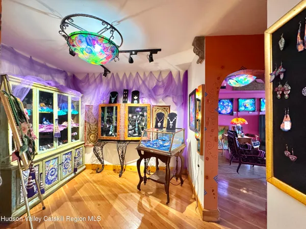a view of a dining room with furniture one side kitchen view and a chandelier