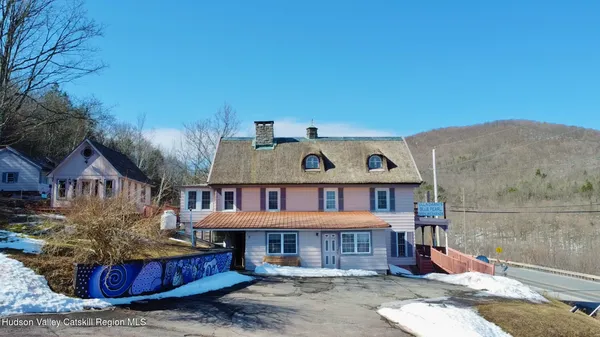 a view of a white house with a large windows and a yard