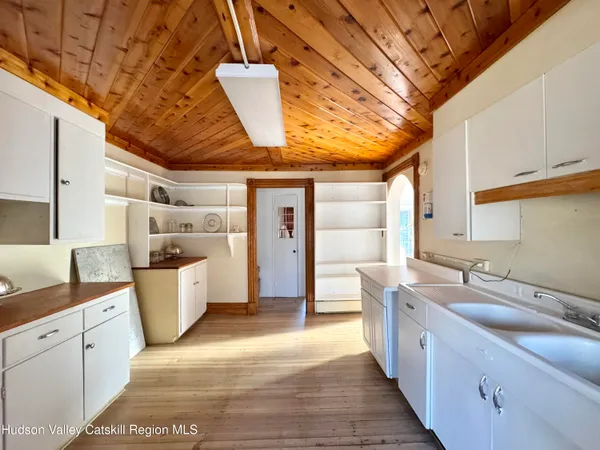 a kitchen with wooden floors and white cabinets