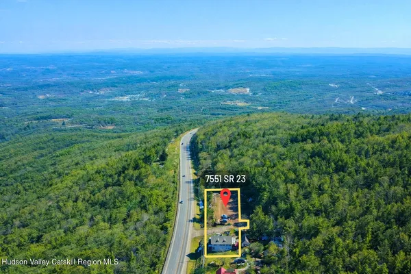 a view of a big house with a big yard and potted plants