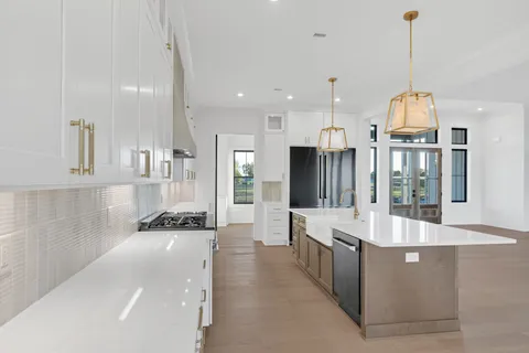 a view of kitchen with stainless steel appliances wooden floor and window
