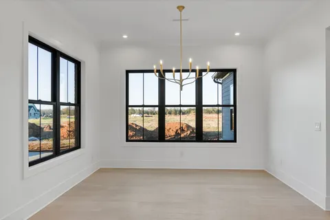 a view of wooden floor in hallway with a mirror