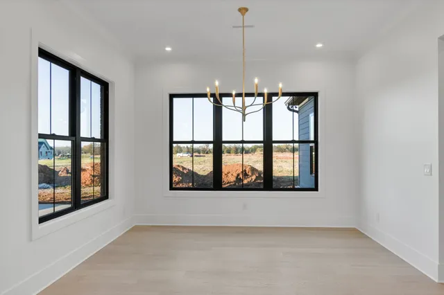 a view of wooden floor in hallway with a mirror