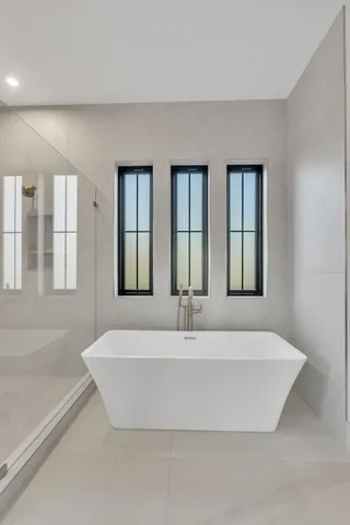 a view of an empty room with wooden floor and windows