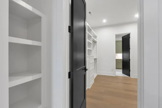 an empty room with windows and ceiling fan