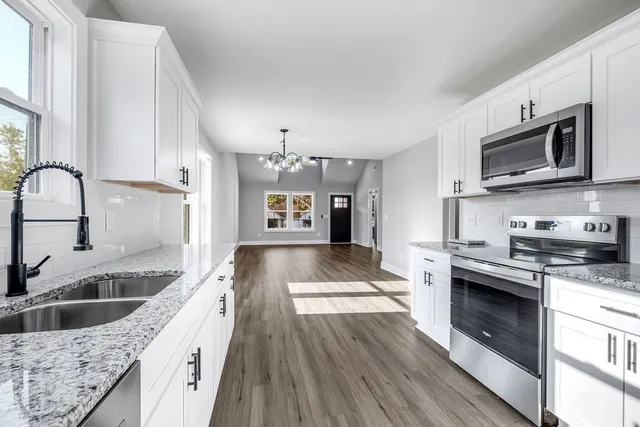 a kitchen with stainless steel appliances granite countertop a sink stove and refrigerator