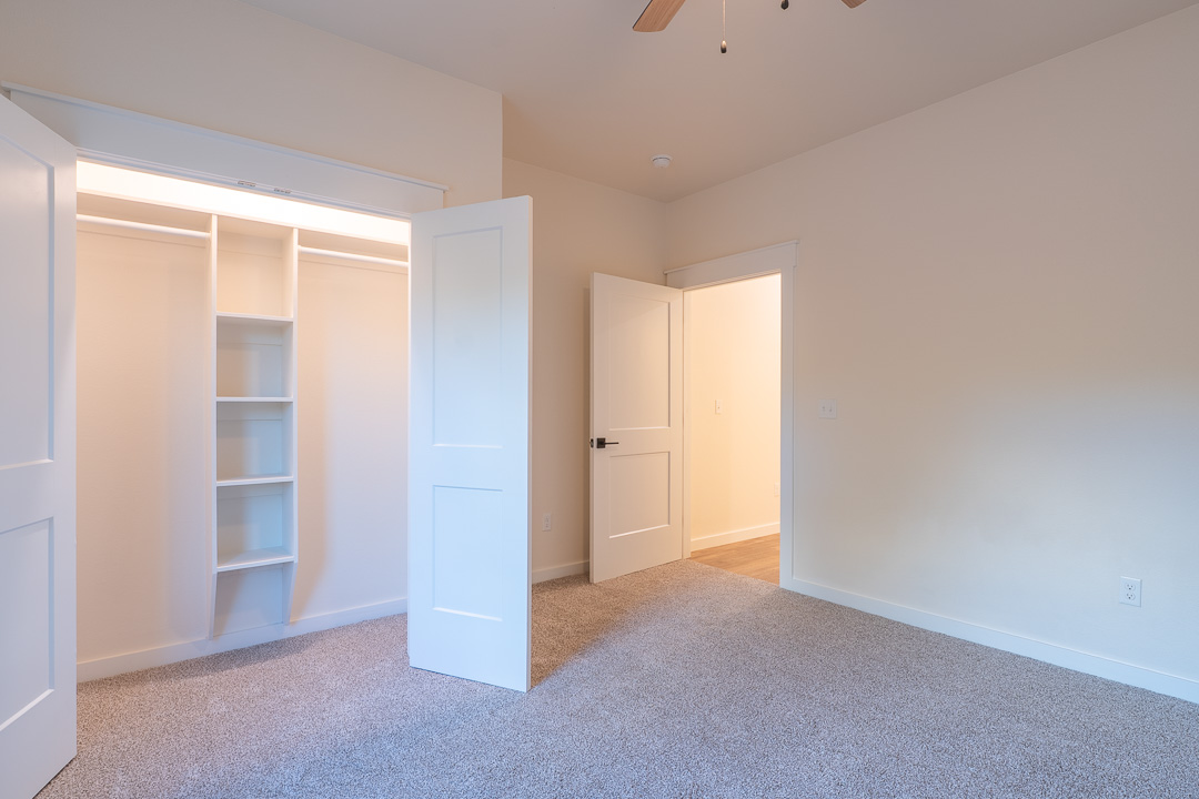 205 Blessings Way Colbert, OK 74733 - Photo 19 of 24 Built-in closet system with shelving and hanging rods, neutral wall color, textured carpeting, and white trim