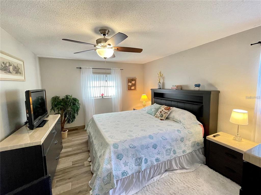 3495 Tree Line Court, Unit 8 Sarasota, FL 34231 - Photo 22 of 40 a bedroom with a bed and a chandelier