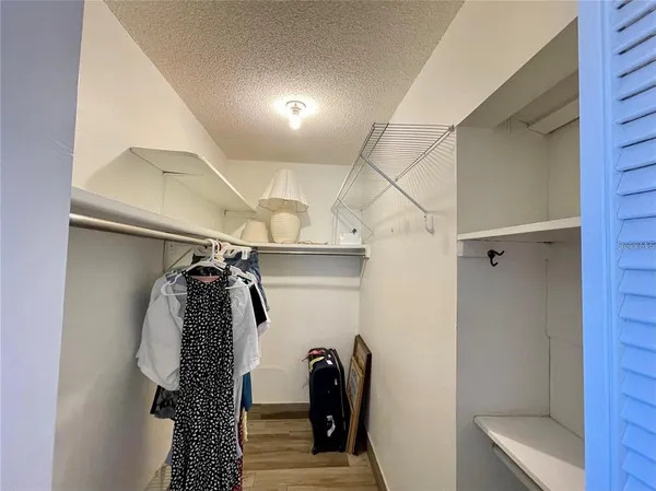 a view of walk in closet with clothes and shoes