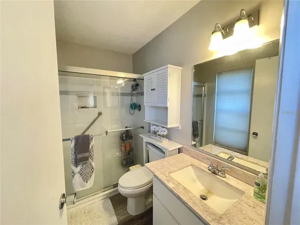 a bathroom with a granite countertop sink toilet and shower