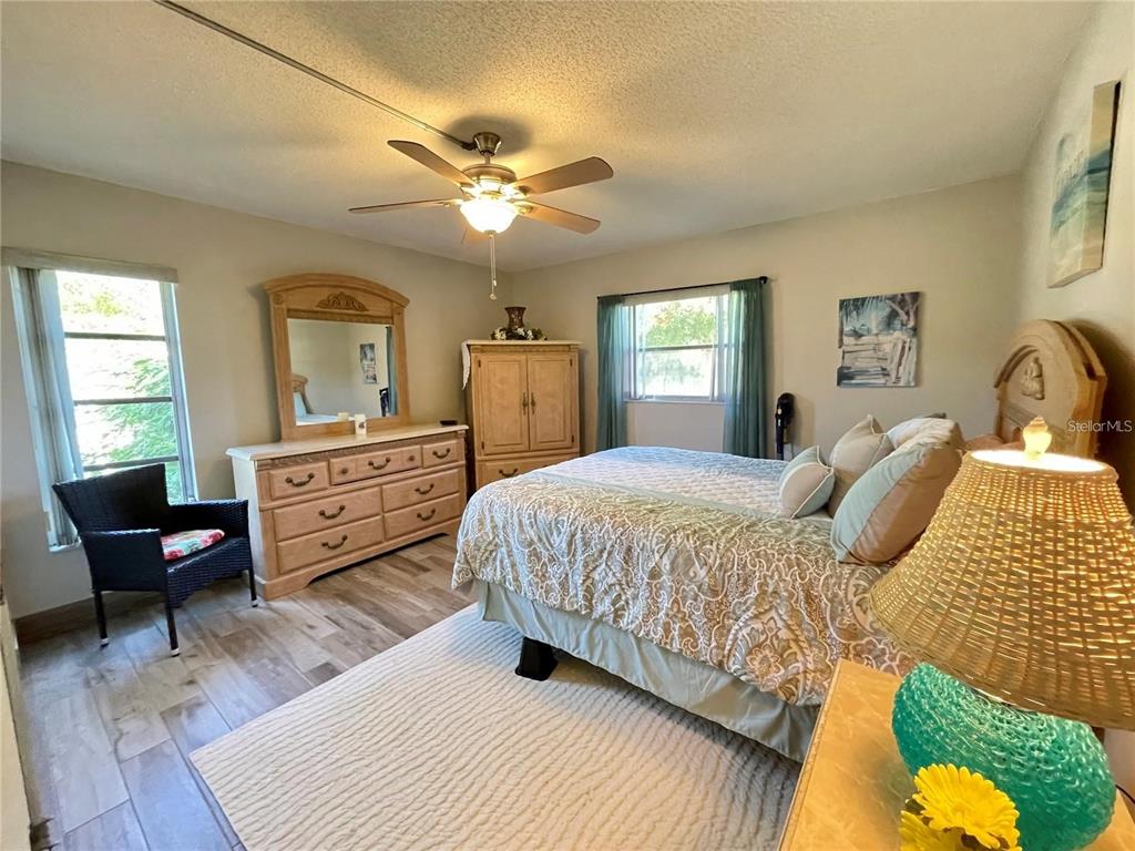 3495 Tree Line Court, Unit 8 Sarasota, FL 34231 - Photo 29 of 40 a bedroom with a bed and dresser with wooden floor