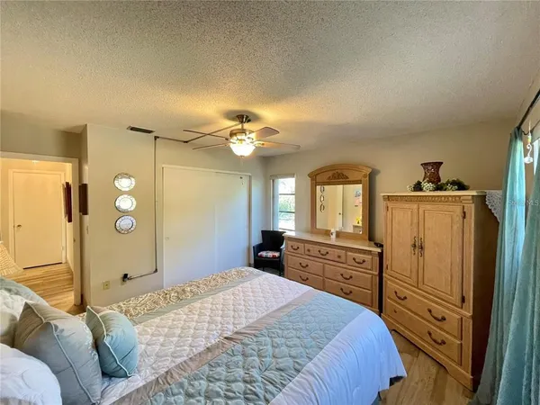 a bedroom with a bed dresser and wooden floor