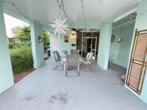 a living room with patio furniture and a potted plant