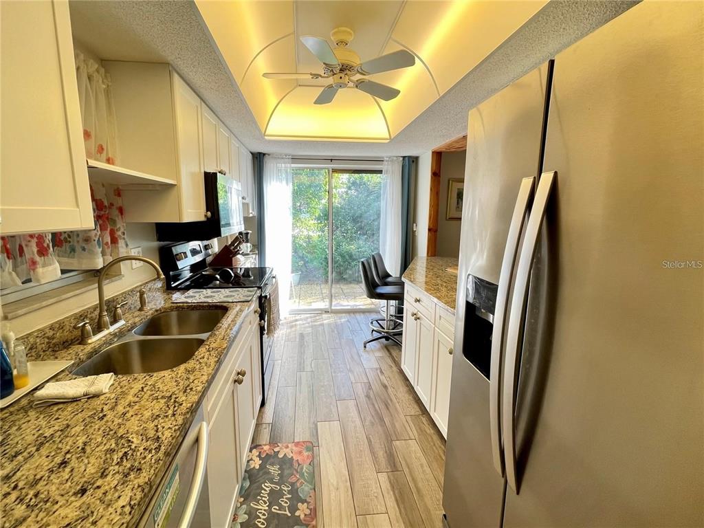3495 Tree Line Court, Unit 8 Sarasota, FL 34231 - Photo 7 of 40 a kitchen with a refrigerator a sink a stove and a refrigerator