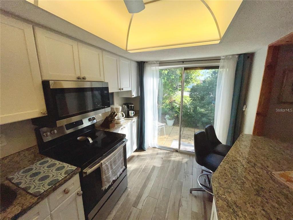 3495 Tree Line Court, Unit 8 Sarasota, FL 34231 - Photo 8 of 40 a kitchen with a stove a sink and a microwave